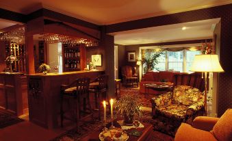 a cozy living room with a fireplace , a bar , and a couch set up for a party at Windham Hill Inn