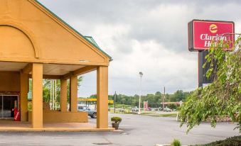 an exterior view of a quality hotel , with a large building in the foreground and a cloudy sky overhead at Hotel Veranda DuBois