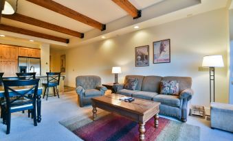 a cozy living room with wooden beams on the ceiling , a couch , and a coffee table at Newpark Resort