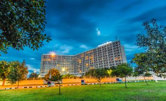 a large hotel building surrounded by grass and trees , with a grassy field in front of it at Transcorp Hilton Abuja