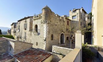 a stone building with a tower and a brick chimney is shown in the image at Chateau le Cagnard