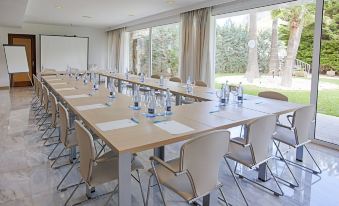 a conference room set up for a meeting , with several chairs arranged in a semicircle around a long table at Grupotel Molins