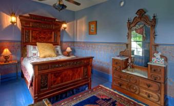 a bedroom with a large wooden bed , dresser , and mirror , as well as a rug on the floor at Gibson House