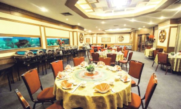 a large dining room with multiple tables and chairs arranged for a group of people to enjoy a meal at Planet Holiday Hotel & Residence