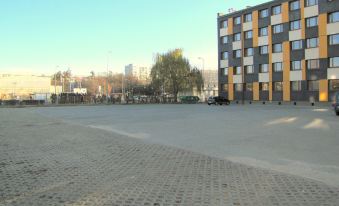 a large , empty parking lot with a building in the background and several cars parked at Boutique Hotel's