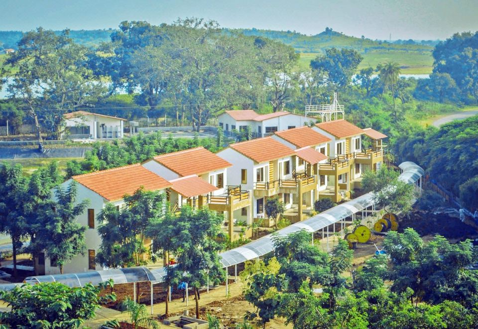 aerial view of a row of multi - story houses with orange roofs surrounded by lush greenery at Graces Resort