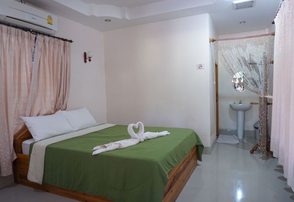 a clean and well - organized bedroom with a large bed , a white door , and a window at Nampueng Resort