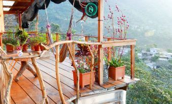 a wooden deck with hanging hammocks , potted plants , and a view of the mountains in the background at Eagle's Retreats