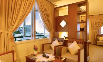 a cozy living room with a couch , chairs , and a dining table in front of a window at Palace Hotel