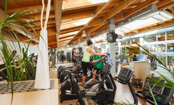 a group of people working out in a gym , with various exercise machines and equipment at Glockenhof