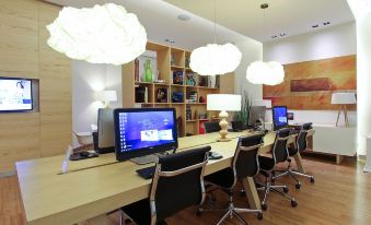 a modern office space with multiple desks and chairs arranged in rows , each equipped with computer monitors and keyboards at Fiesta Inn Express Queretaro Constituyentes