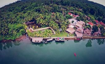 an aerial view of a tropical island with a house surrounded by trees and a body of water at Shane Josa Resort