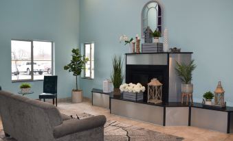 a living room with a fireplace and various decorative items , including vases and potted plants at Metropolis Resort - Eau Claire