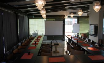 a conference room set up for a meeting , with multiple tables and chairs arranged in a semicircle at Oxford Hotel