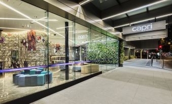 "a modern glass building with large windows , offering views of the interior , and the word "" cafe "" displayed above the entrance" at Capri by Fraser Brisbane