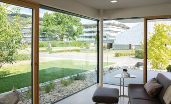 a modern living room with large glass windows , allowing natural light to fill the space at Lumina Apartments