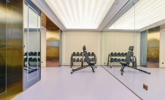 There is a spacious room with multiple exercise equipment and an air hockey table located in the center at Mercure Shanghai Hongqiao SOHO