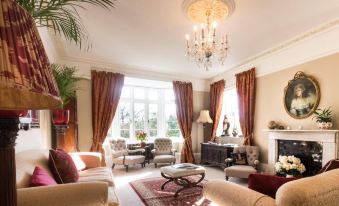 a well - decorated living room with various furniture , including a couch , chairs , and a dining table at Blaisdon House B&B