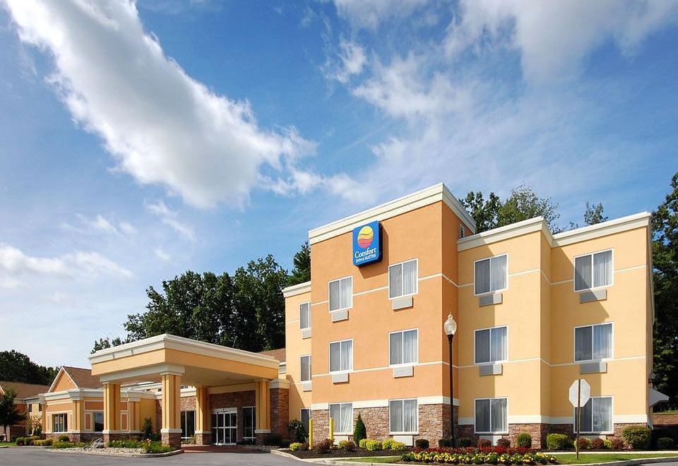 an exterior view of a comfort suites hotel with a large parking lot in front of it at Comfort Inn & Suites Saratoga Springs