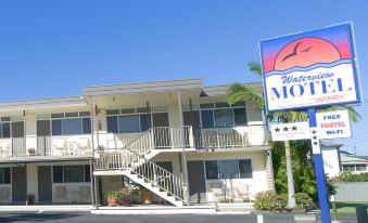a motel with multiple rooms , a staircase leading to the entrance , and a sign in front of the building at Waterview Motel Maclean