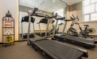 a well - equipped gym with various exercise equipment , including treadmills and stationary bikes , in a spacious room at Atour Hotel
