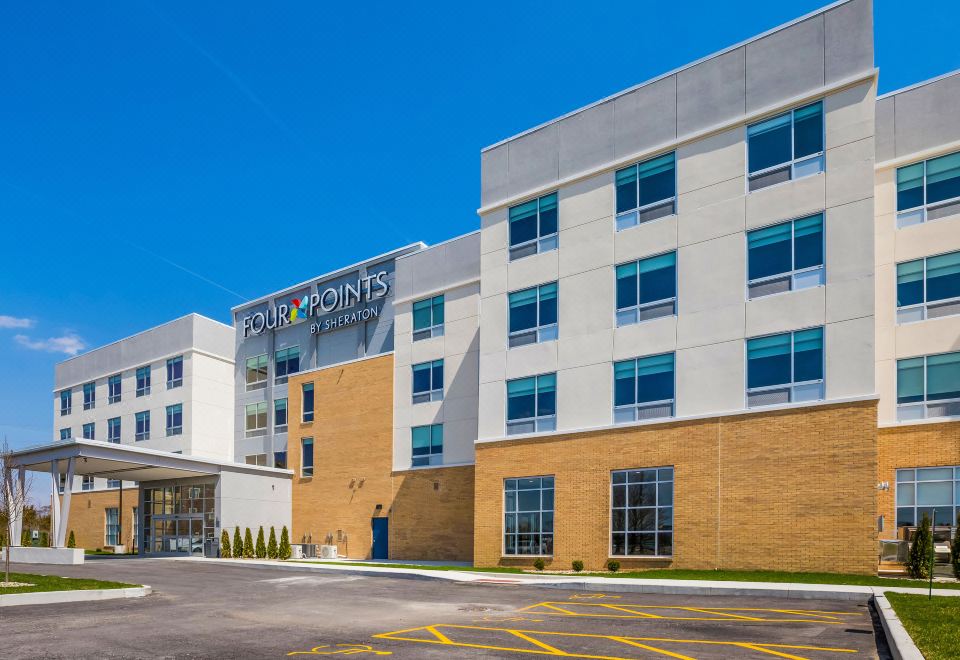"a modern hotel building with the words "" holiday inn express "" prominently displayed on its side" at Four Points by Sheraton Elkhart