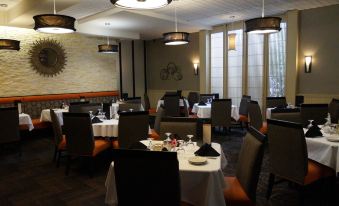 a well - lit dining room with tables and chairs arranged for a group of people to enjoy a meal together at Holiday Inn Portsmouth Downtown