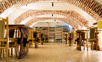 a wine cellar with various bottles of wine arranged on shelves , along with wooden tables and chairs at Nest