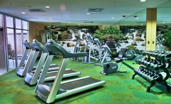 a gym with various exercise equipment , including treadmills and stationary bikes , in a large room at SpringHill Suites Pueblo Downtown