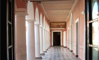 a long hallway with white columns on both sides and a door at the end at Casa del Arbol Hostel