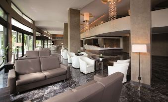 a modern living room with white and gray furniture , a marble floor , and large windows at Hotel Majestic