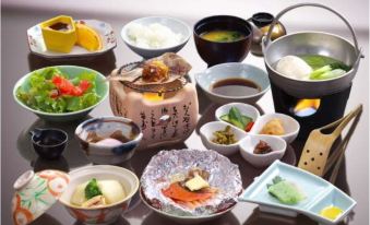 a dining table filled with a variety of japanese dishes , including bowls , plates , and utensils at Naraya