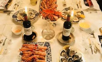 a dining table filled with a variety of seafood , including shrimp , oysters , and mussels , as well as other food items at The Good House
