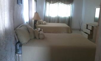 a room with two beds , one on the left side and the other on the right side of the room at Cottage Cut Villas