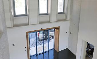 a white building with three large windows and a wooden door , allowing natural light to fill the space at Fleur de LIS