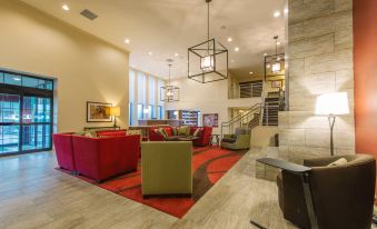 a large , modern hotel lobby with multiple couches , chairs , and tables arranged for guests to sit and relax at Hotel Mtk Mount Kisco