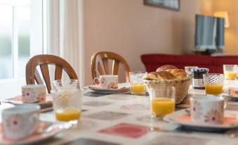 a dining table is set with a variety of breakfast items , including orange juice and bread at L'Olivier