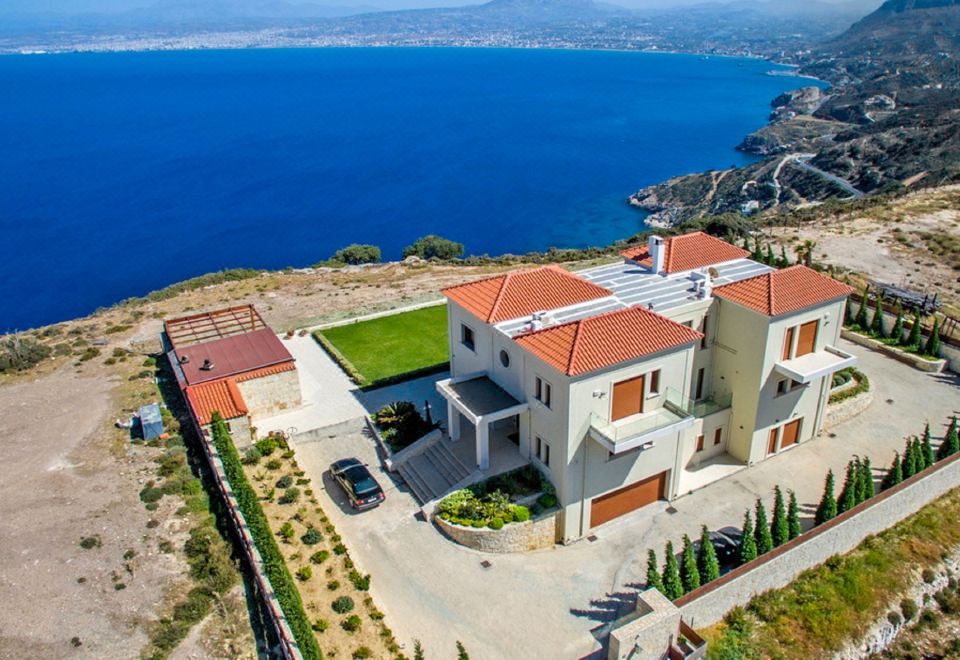 a large white house situated on top of a hill overlooking a body of water at Azure