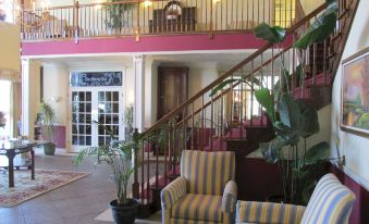 a staircase leading to the second floor of a building , with a seating area on the second floor at White Columns Inn