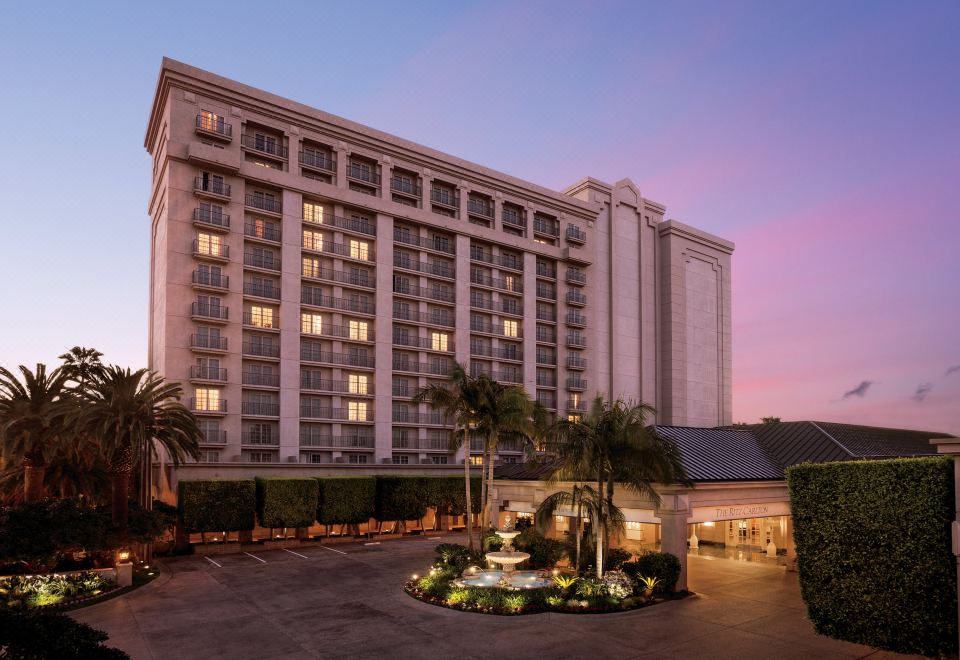 a large hotel building with a fountain in front of it , surrounded by palm trees at The Ritz-Carlton, Marina del Rey