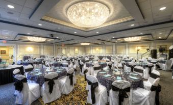 a large banquet hall with many tables and chairs , a chandelier , and a carpet at The Inn at Wise