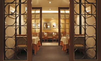 a dining room with wooden tables and chairs arranged for a group of people to sit and enjoy their meal at Nagoya Tokyu Hotel