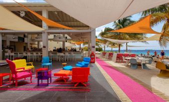 a colorful outdoor seating area with several chairs and umbrellas , providing a comfortable atmosphere for guests at Papagayo Beach Resort
