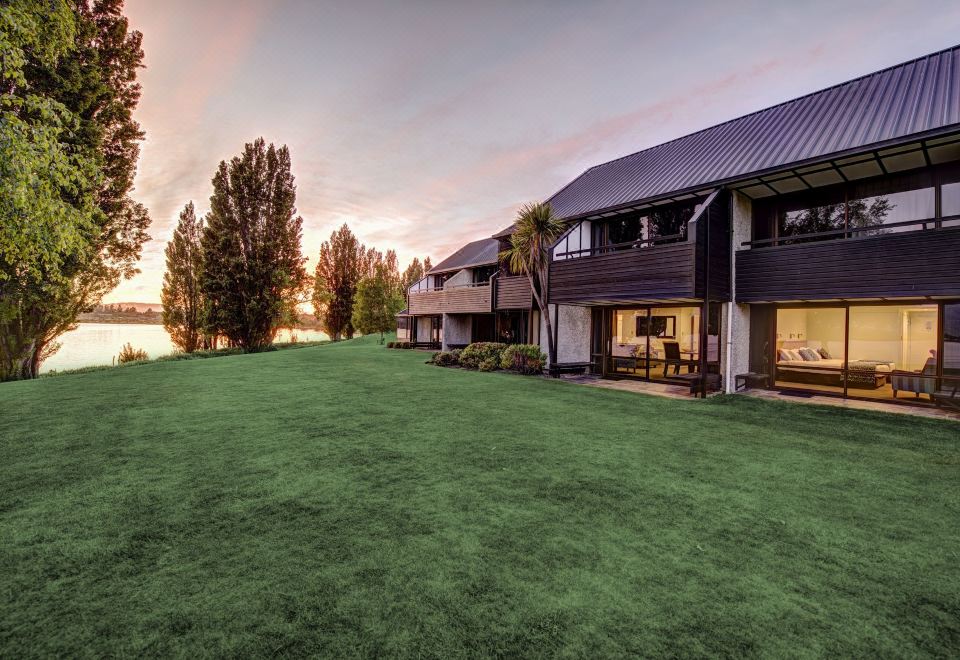 a large house with a grassy yard and a view of the water in the background at Edgewater Hotel