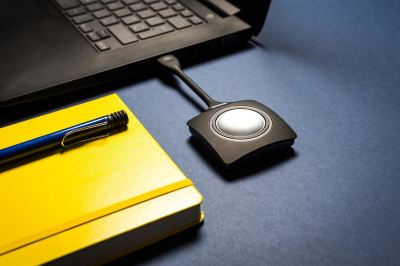 a black button is connected to a yellow notebook next to a black pen on a blue table at Village Hotel Liverpool