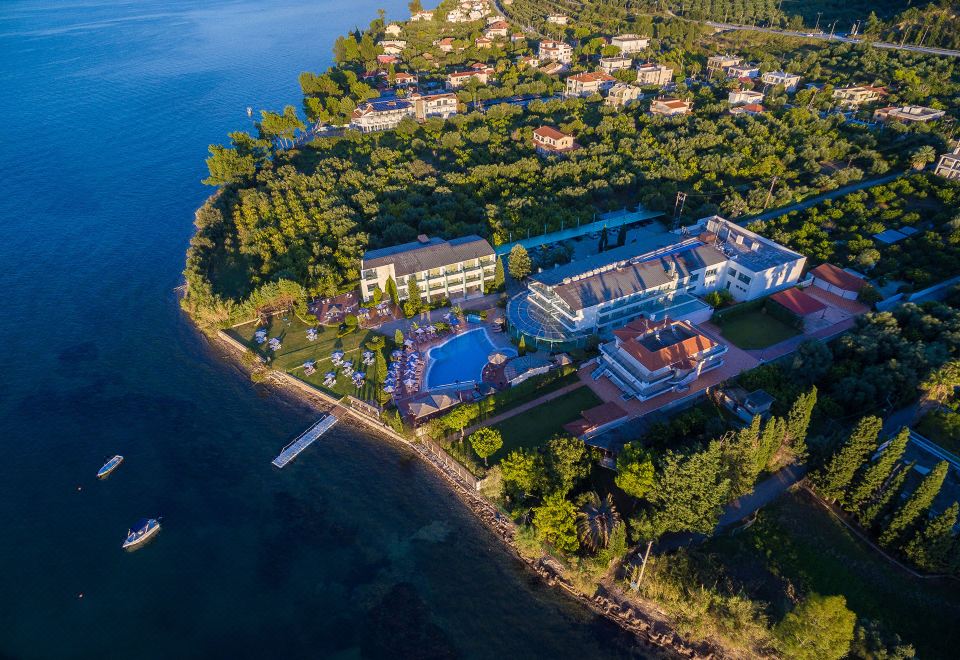 aerial view of a resort on the coast , with a large pool and multiple buildings surrounding it at Poseidon Palace