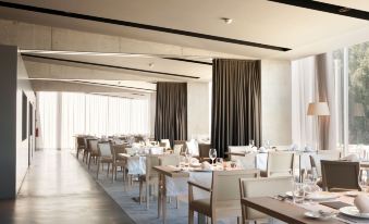 a large dining room with white tables and chairs arranged for a group of people at Octant Douro