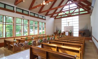 a church with wooden pews and a large window , giving it a serene and peaceful atmosphere at Courtyard by Marriott Hakuba