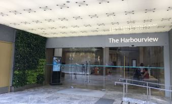 There is a building with a glass fronted door and an illuminated sign above its entrance at The Harbourview-Chinese YMCA of Hong Kong