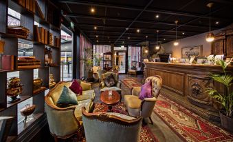 a cozy hotel lobby with comfortable seating , a bar , and a fireplace , creating a warm and inviting atmosphere at Best Western the Public Hotel